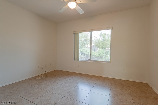 empty room with ceiling fan and light tile patterned flooring