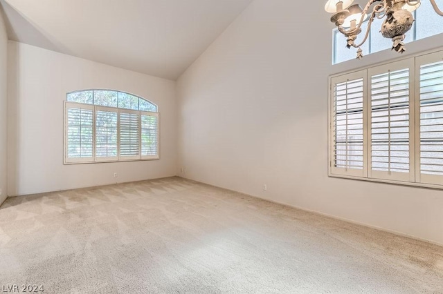 unfurnished room with light colored carpet and high vaulted ceiling