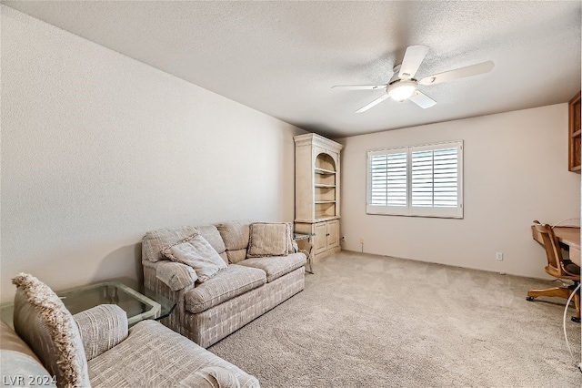 carpeted living room featuring ceiling fan and a textured ceiling