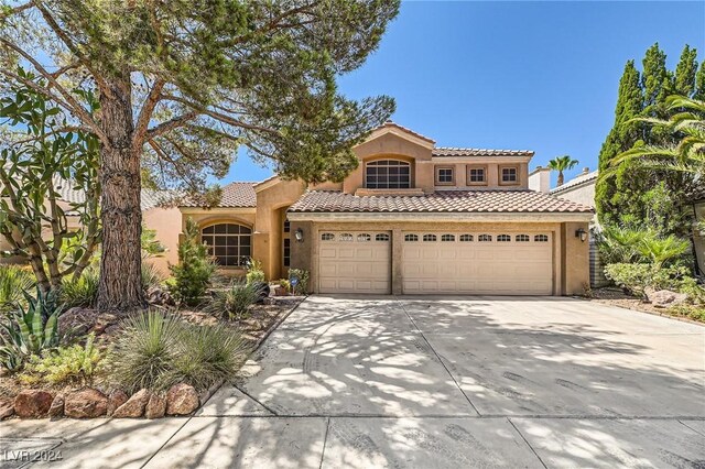 mediterranean / spanish-style home with a garage