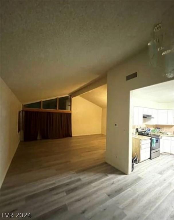 bonus room with light hardwood / wood-style floors and vaulted ceiling