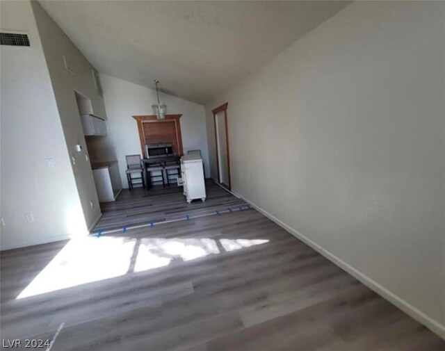 unfurnished living room with vaulted ceiling and hardwood / wood-style floors