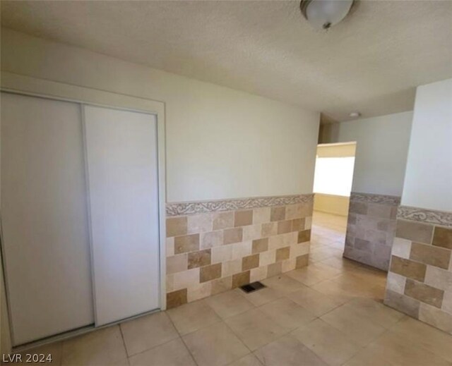 unfurnished room with light tile floors