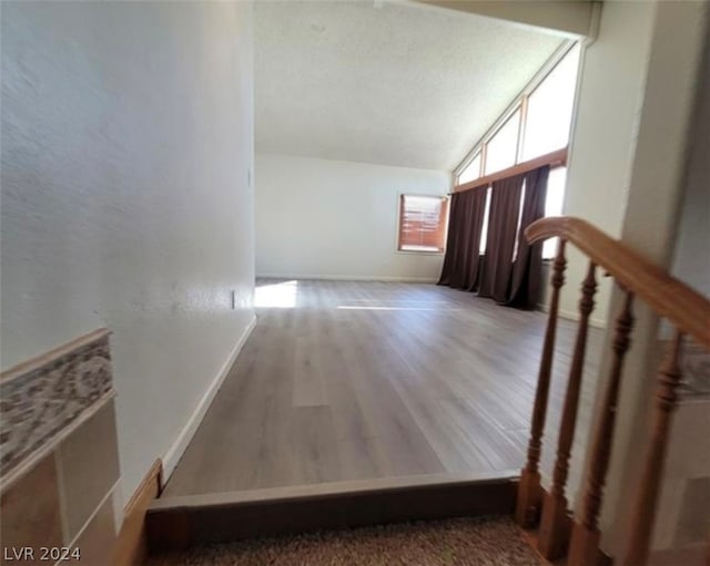 stairs with hardwood / wood-style floors and lofted ceiling