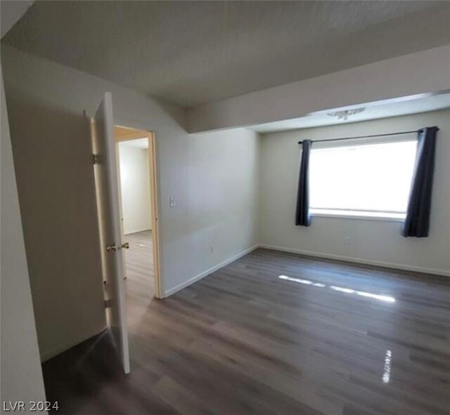 empty room with dark hardwood / wood-style floors