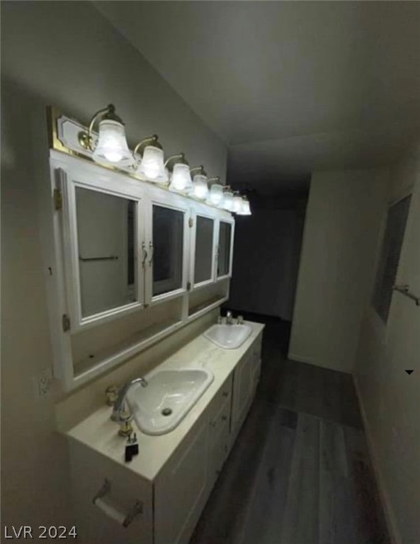 bathroom with wood-type flooring, double vanity, and vaulted ceiling