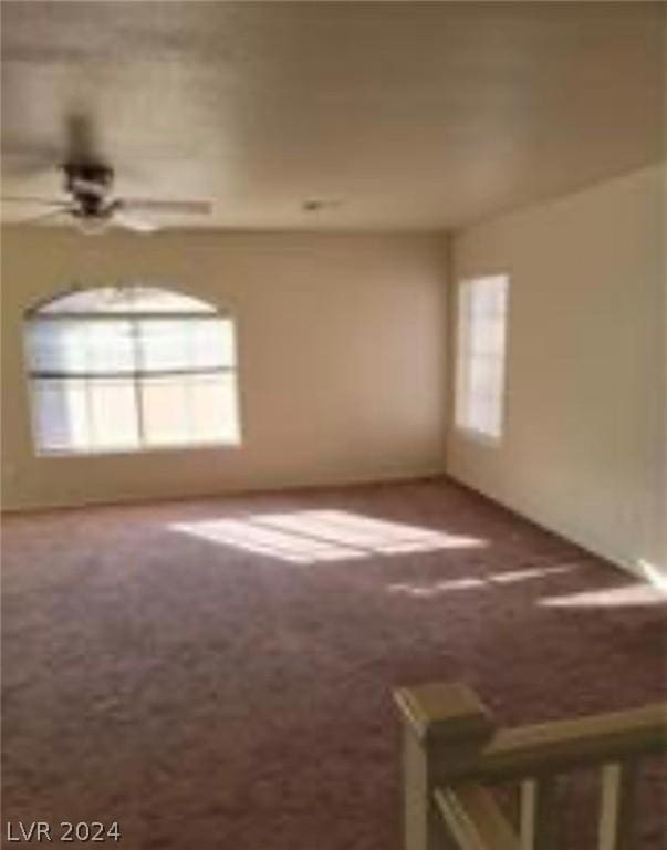 empty room with ceiling fan and carpet