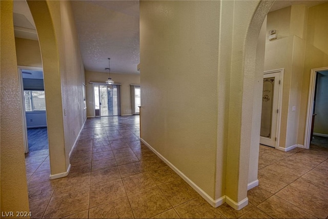 hall featuring tile floors and a textured ceiling