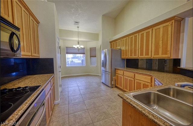 kitchen featuring decorative light fixtures, stainless steel appliances, a notable chandelier, sink, and light tile floors