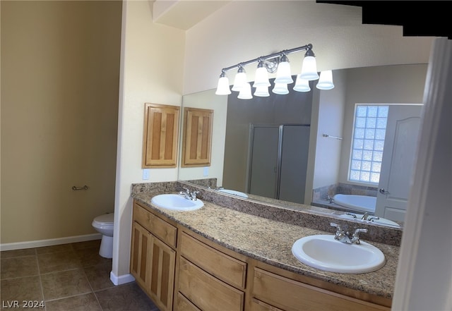 bathroom featuring double vanity, tile flooring, toilet, and a bathing tub