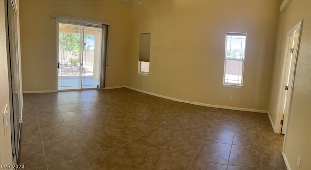 tiled spare room with a high ceiling and plenty of natural light