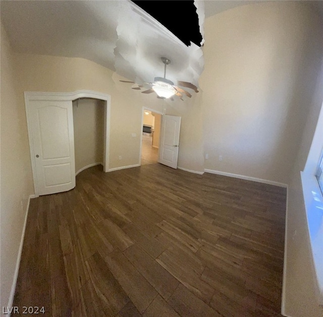 unfurnished bedroom with ceiling fan, vaulted ceiling, and dark wood-type flooring