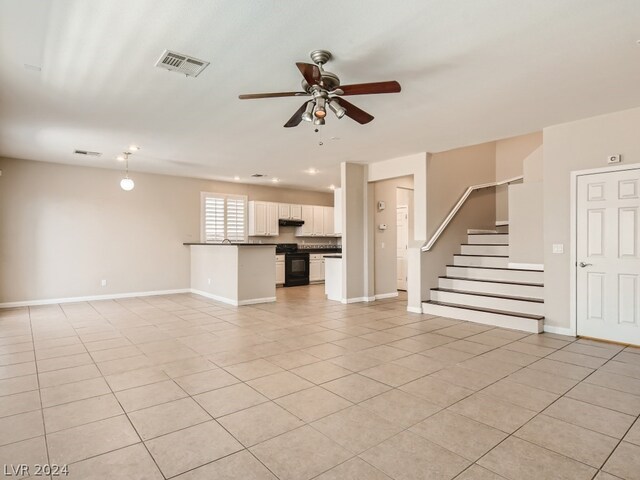 unfurnished living room featuring ceiling fan and light tile floors