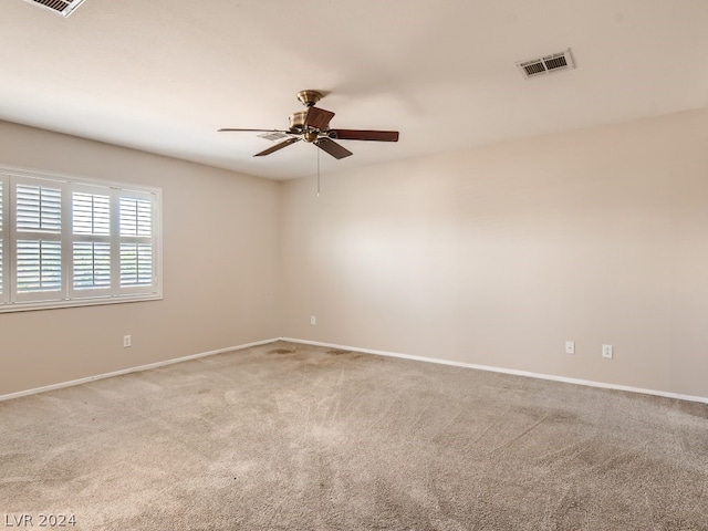 carpeted spare room with ceiling fan