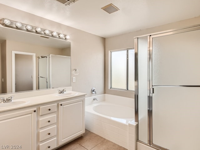 bathroom with tile flooring, dual vanity, and separate shower and tub