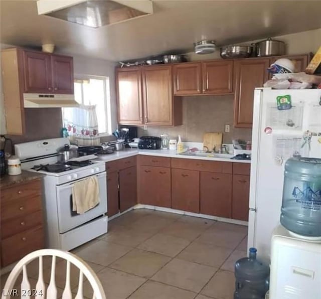 kitchen with light tile patterned floors, sink, extractor fan, and white appliances