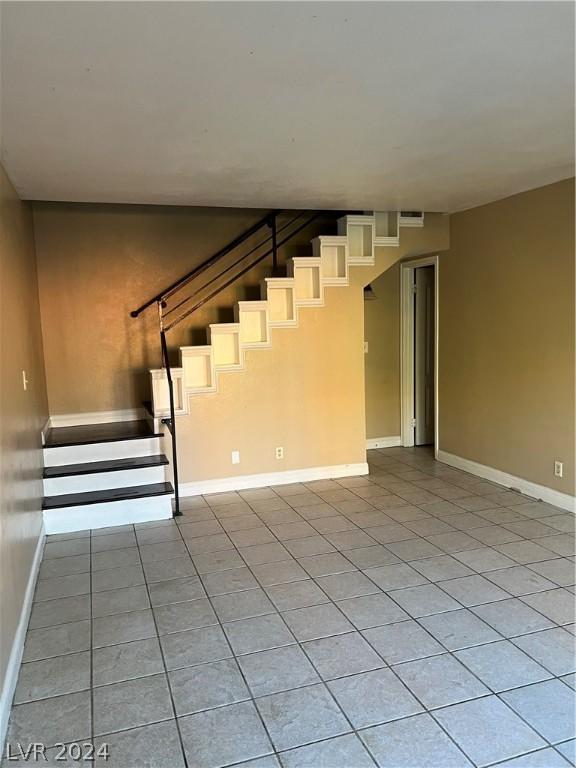 stairway featuring baseboards and tile patterned floors