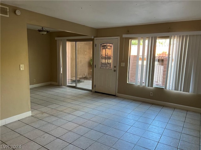 foyer entrance with light tile patterned flooring, visible vents, and baseboards