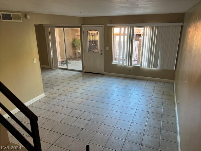 empty room with visible vents, baseboards, and light tile patterned flooring