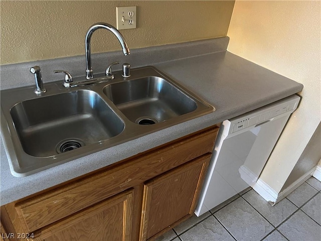 room details featuring a textured wall, a sink, light countertops, brown cabinets, and dishwasher