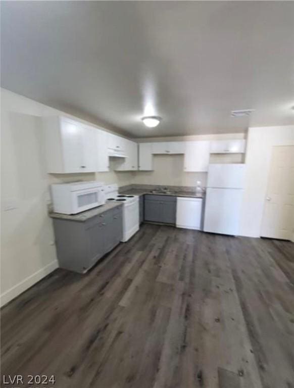 kitchen featuring white appliances, dark wood-type flooring, and white cabinets