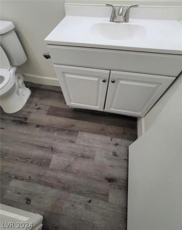 bathroom with vanity, wood-type flooring, and toilet