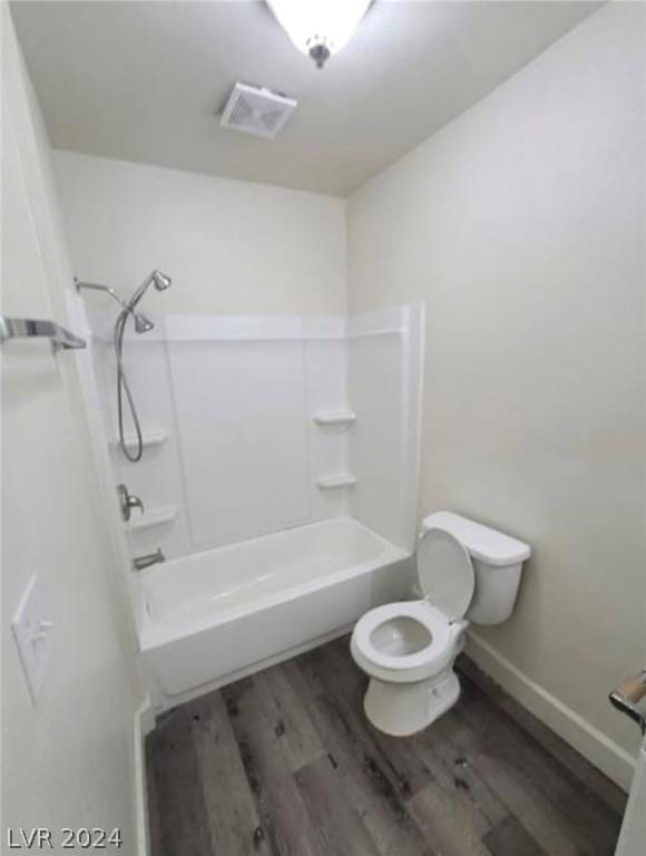 bathroom featuring shower / tub combination, wood-type flooring, and toilet