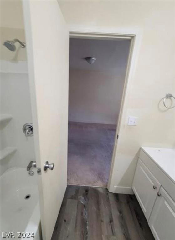 bathroom featuring vanity, wood-type flooring, and  shower combination