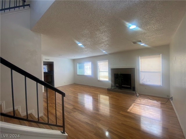 unfurnished living room with a textured ceiling and hardwood / wood-style flooring