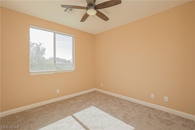 carpeted spare room featuring ceiling fan