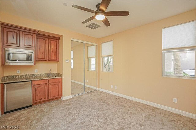 kitchen featuring stainless steel appliances, light colored carpet, a wealth of natural light, and ceiling fan