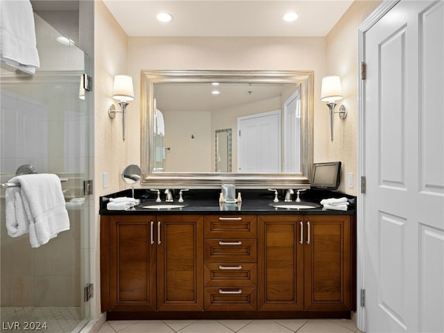 bathroom with vanity, a shower with shower door, and tile patterned flooring