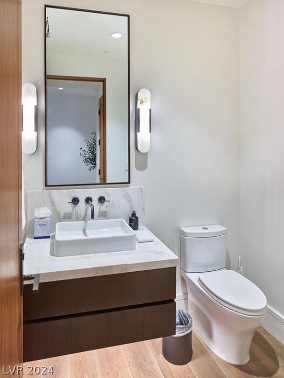 bathroom featuring tasteful backsplash, toilet, and vanity