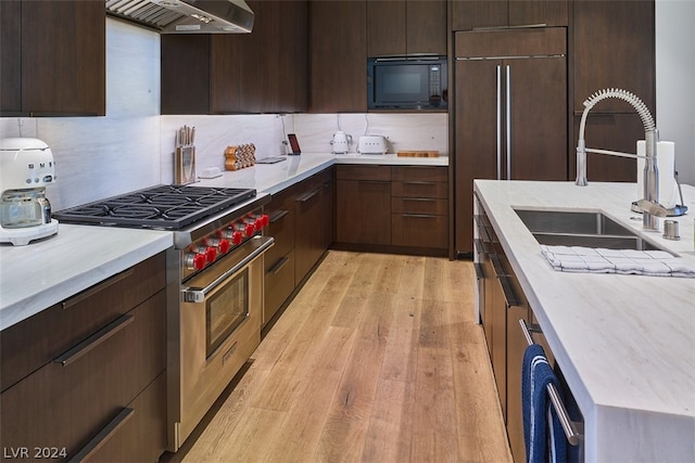 kitchen with premium range, wall chimney exhaust hood, tasteful backsplash, black microwave, and sink