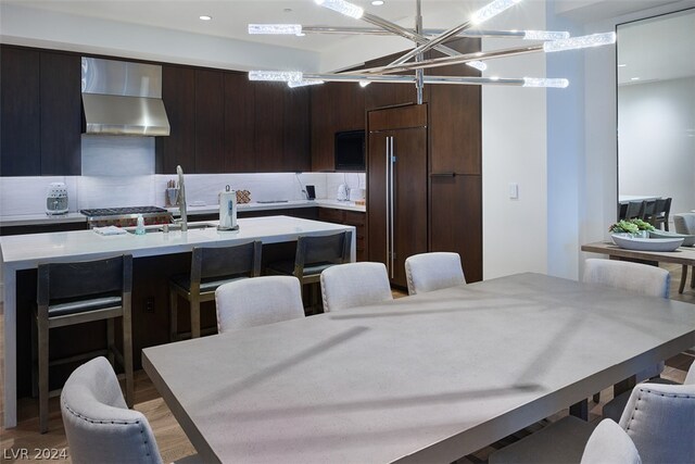 dining space with light wood-type flooring, sink, and an inviting chandelier