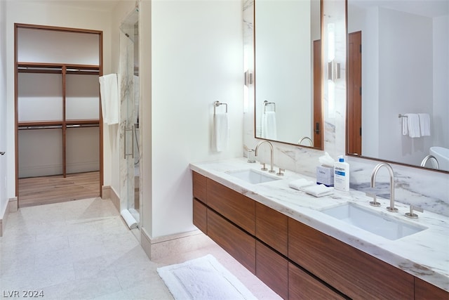 bathroom with hardwood / wood-style floors, double vanity, and a shower with shower door