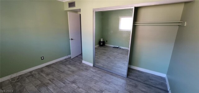 unfurnished bedroom featuring a closet and wood-type flooring