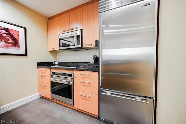 kitchen featuring light tile patterned flooring and appliances with stainless steel finishes