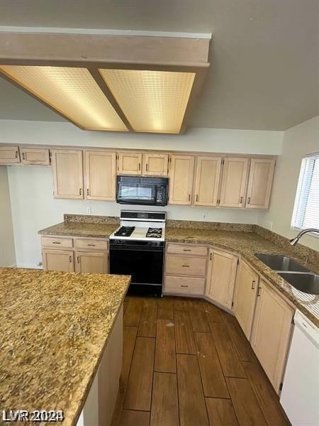 kitchen featuring range with gas cooktop, dark wood-type flooring, dishwasher, light stone counters, and sink