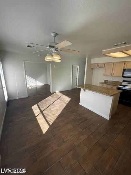 kitchen with ceiling fan, electric range, light brown cabinetry, and a kitchen island