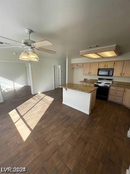 kitchen with ceiling fan, a kitchen island, a breakfast bar area, light brown cabinetry, and range with gas stovetop