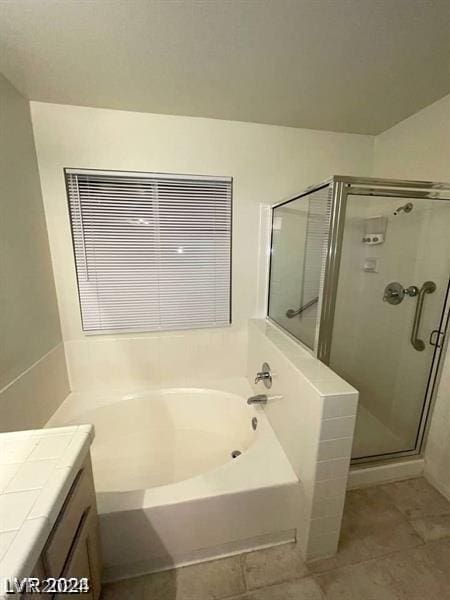 bathroom with tile patterned floors, vanity, and separate shower and tub