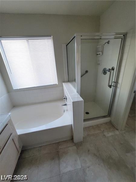 bathroom with vanity and shower with separate bathtub