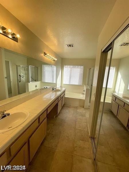 bathroom with vanity and shower with separate bathtub