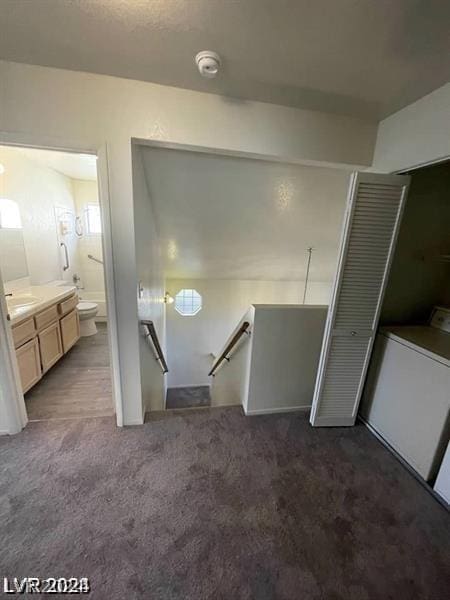 bathroom with toilet, vanity, and washer / dryer