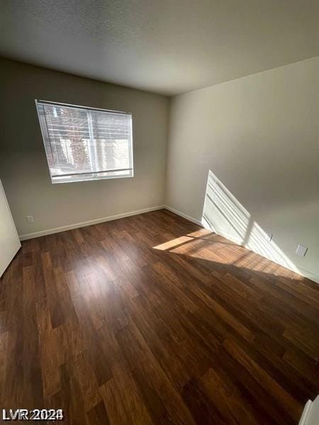 unfurnished room featuring dark wood-type flooring