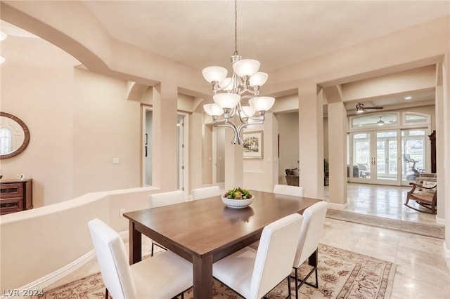 tiled dining space with french doors and ceiling fan with notable chandelier