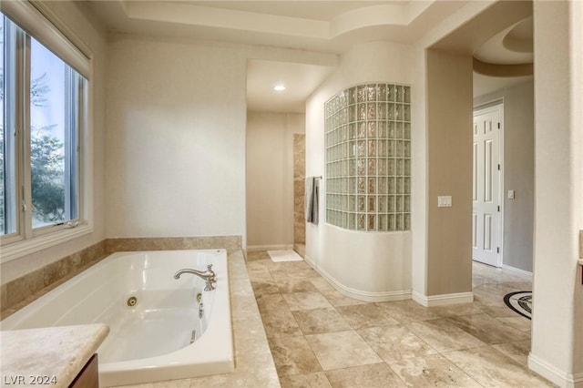 bathroom featuring vanity and tiled tub