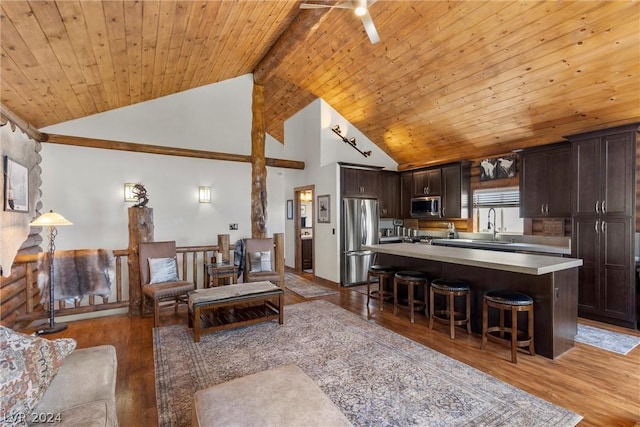 living room with hardwood / wood-style floors, wooden ceiling, high vaulted ceiling, beam ceiling, and sink