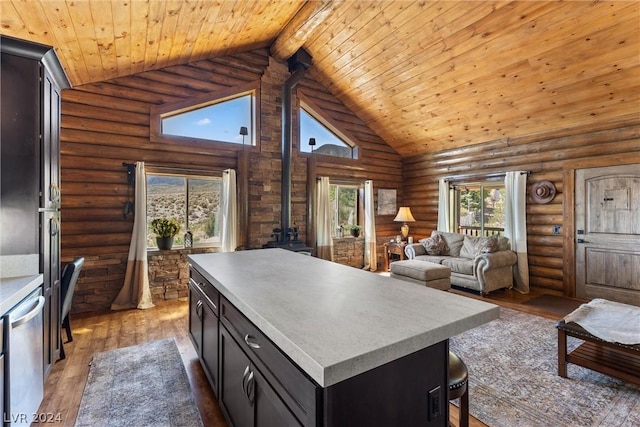 kitchen featuring a wood stove, dark hardwood / wood-style floors, log walls, beam ceiling, and a center island